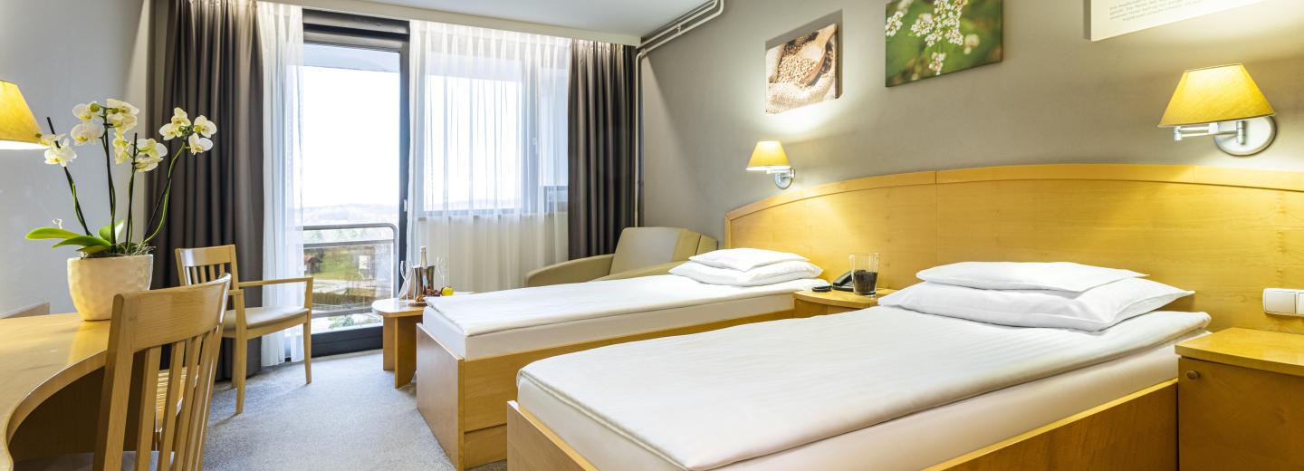 Szoba példa, kétágyas szoba (DZ) „erkély parkra néző”